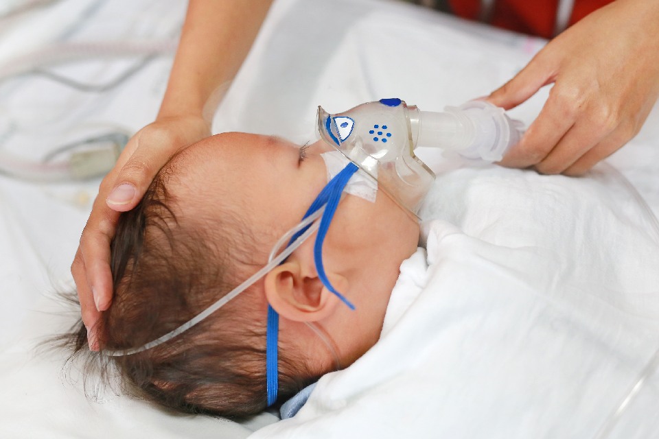 Bebé con mascarilla de oxígeno